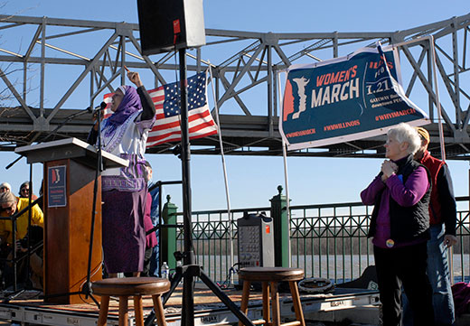 Dr. Rahmat Na’Allah addresses about 1,200 people at the Peoria Women’s March Jan. 21, proclaiming everyone deserves access to health care. Standing to her right is Nora Sullivan who organized the event with Sandy Crow.
