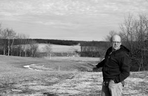 Photo by Clare Howard Organic farmer Henry Brockman points across his field to a path cut through a hillside once forested with oaks. The Enbridge Flanagan South pipeline transects his land and became operational months ago with none of the organized protests surrounding Keystone XL.