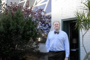 PHOTO BY CLARE HOWARD Hugh Toner stands outside his office in the alleyway separating his building from the former Wilton Mortuary. A common cultural practice was taking a last photograph of a person’s corpse. Bodies would be transported from the mortuary across the alleyway to the photo studio with its large 20-foot by 20-foot skylight. 