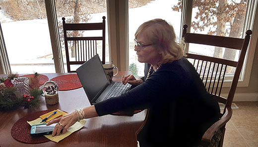 Karen Hudson works at her desk in her rural Peoria County home. After two years of legal haggling, a contempt of court charge against Hudson was summarily reversed by the Fourth District Appellate Court. The charges against Hudson stemmed from allegations by representatives of a CAFO that was in court over nuisance complaints. The contempt of court charge against Hudson was then used as justification to declare a mistrial. 